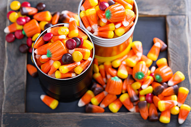 Halloween candy in small tins on brown rustic table